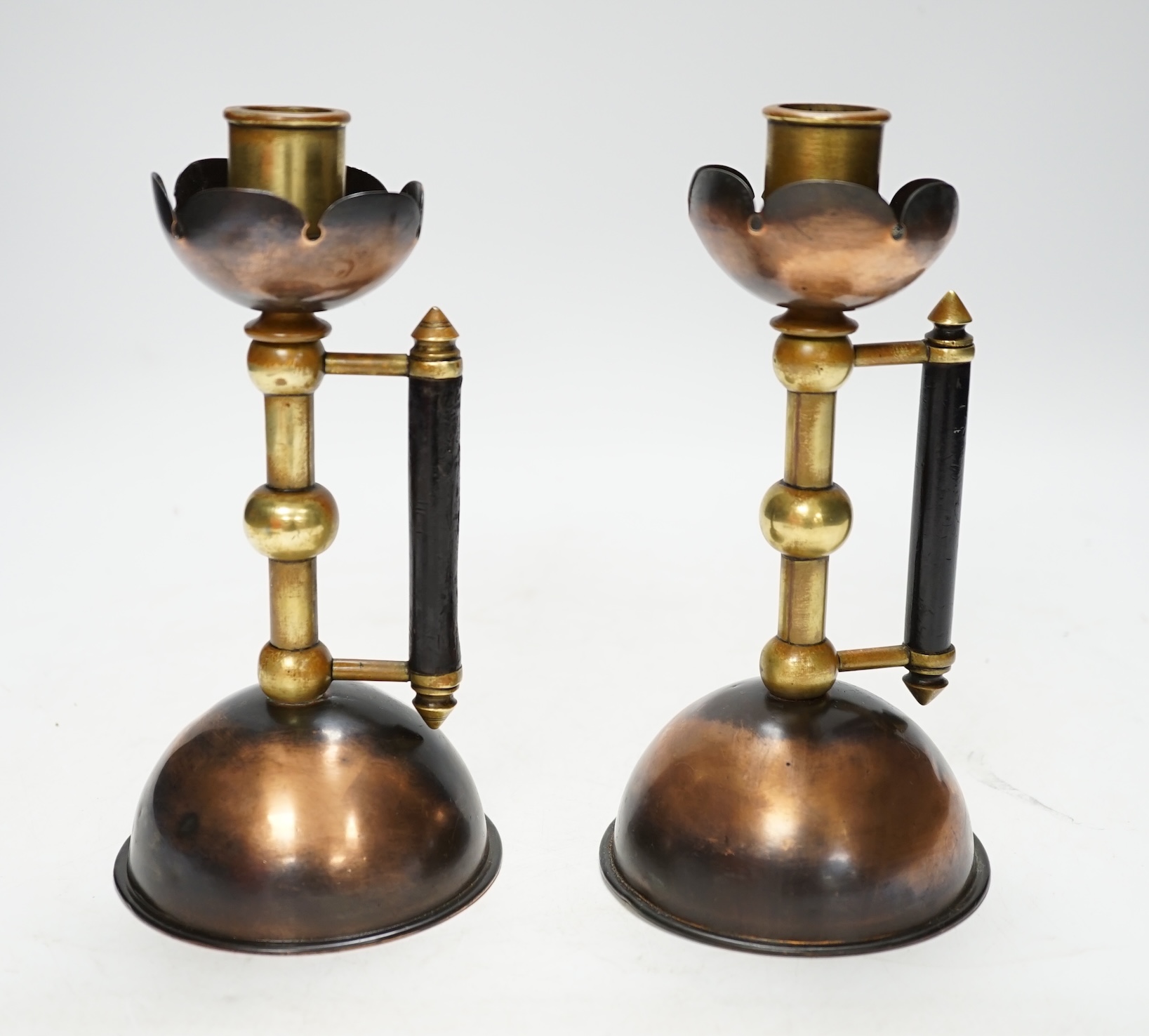Christopher Dresser, a pair of copper and brass candlesticks by Benham and Froud, 18.5cm. Condition - fair
